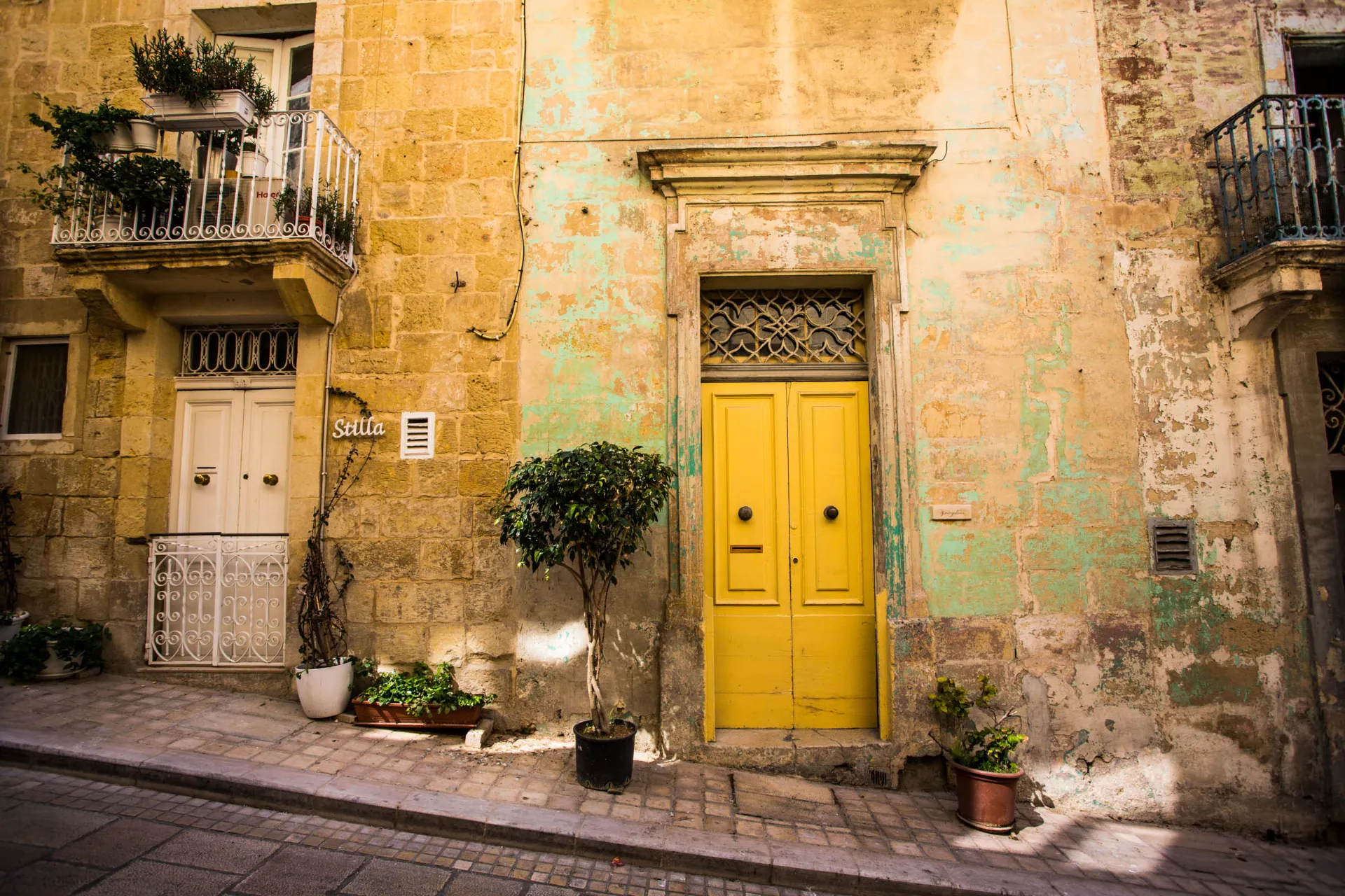 Charmerende facade med gul dør i Vittoriosa – et eksempel på Maltas farverige bymiljø Charmerende facade med gul dør i Vittoriosa – et eksempel på Maltas farverige bymiljø