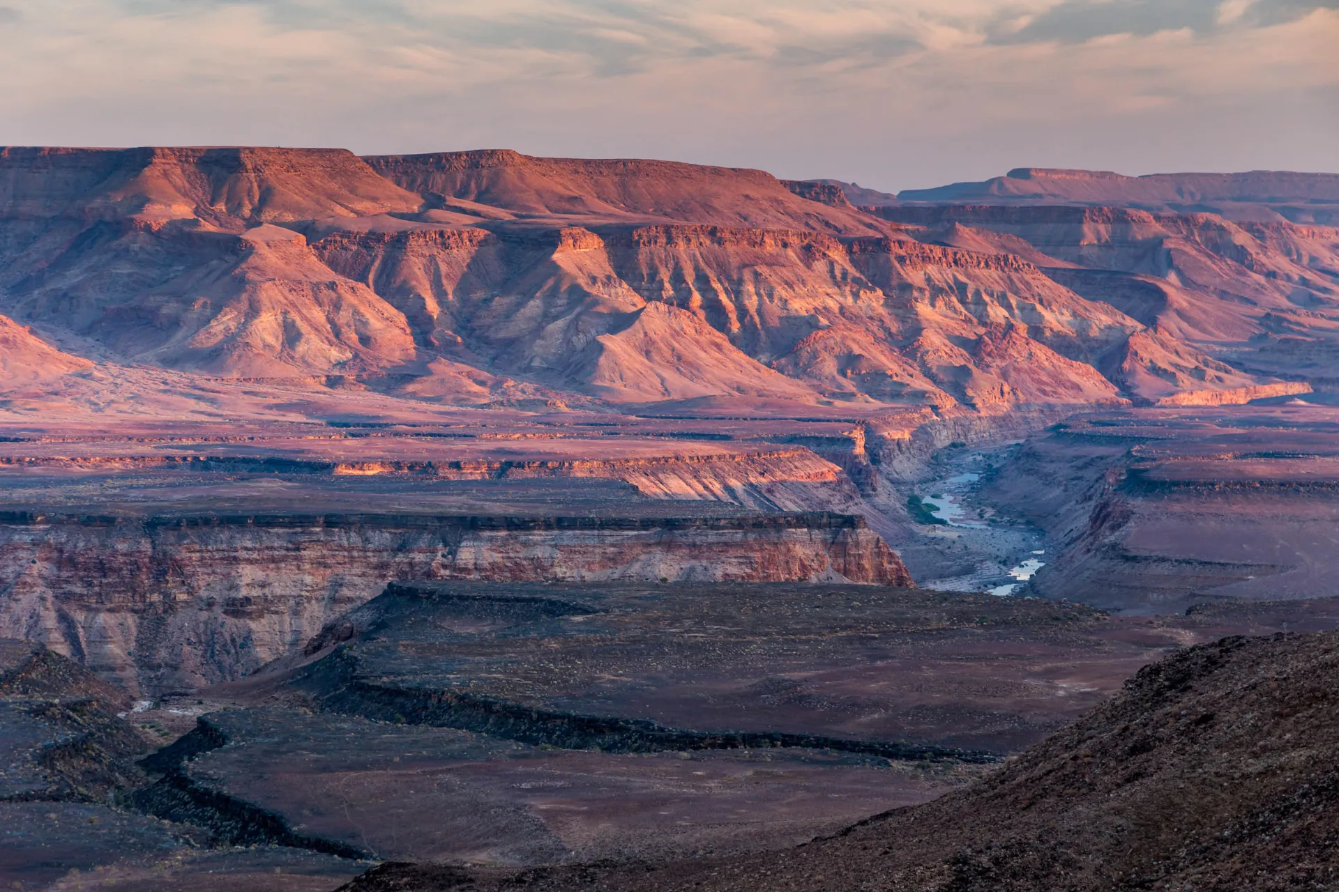 Morgenlyset farver de rå klippeformationer i Fish River Canyon i Namibia Morgenlyset farver de rå klippeformationer i Fish River Canyon i Namibia