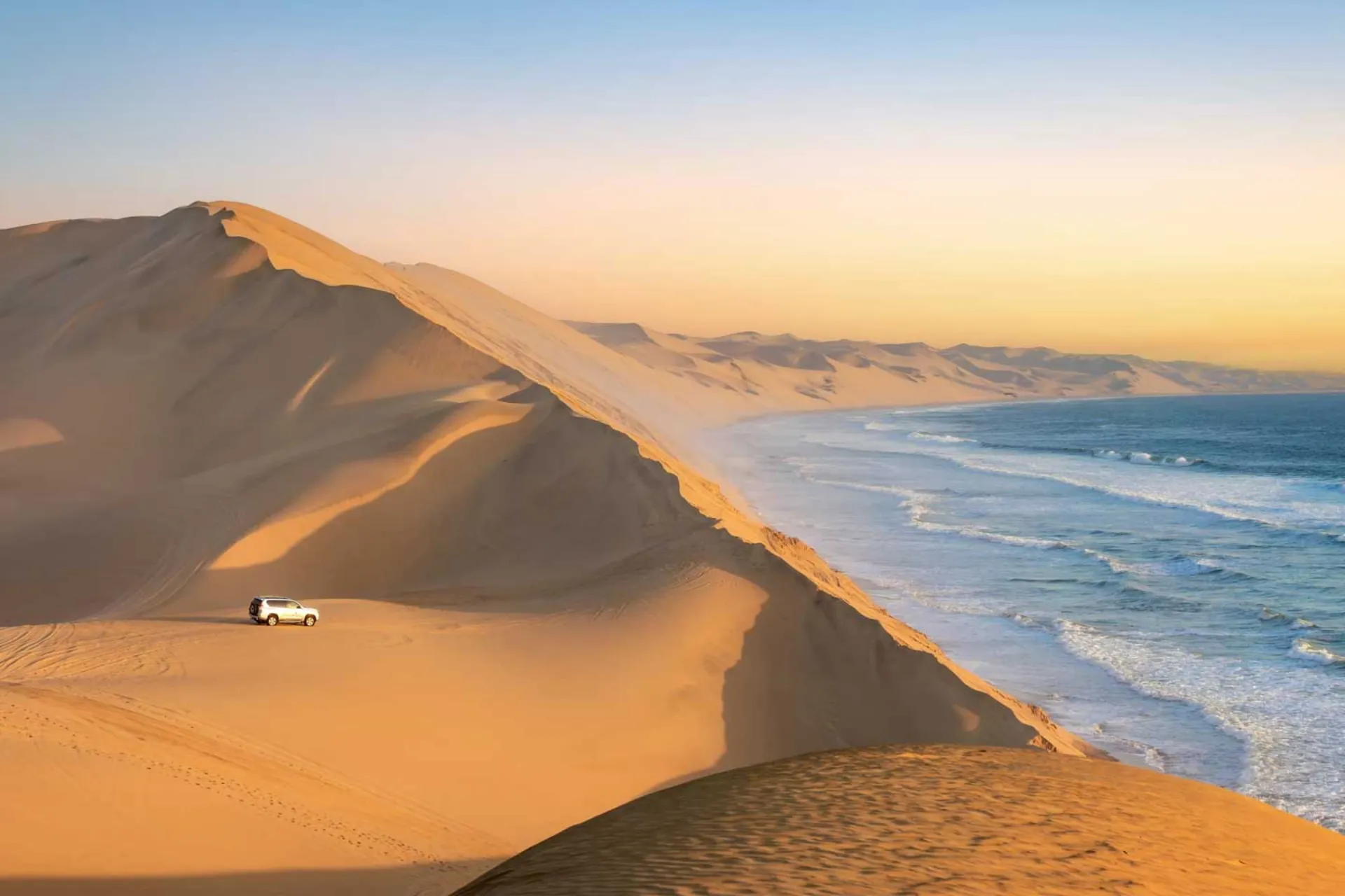Sandwich Harbour i Namibia, hvor de høje klitter skråner direkte ned i havet