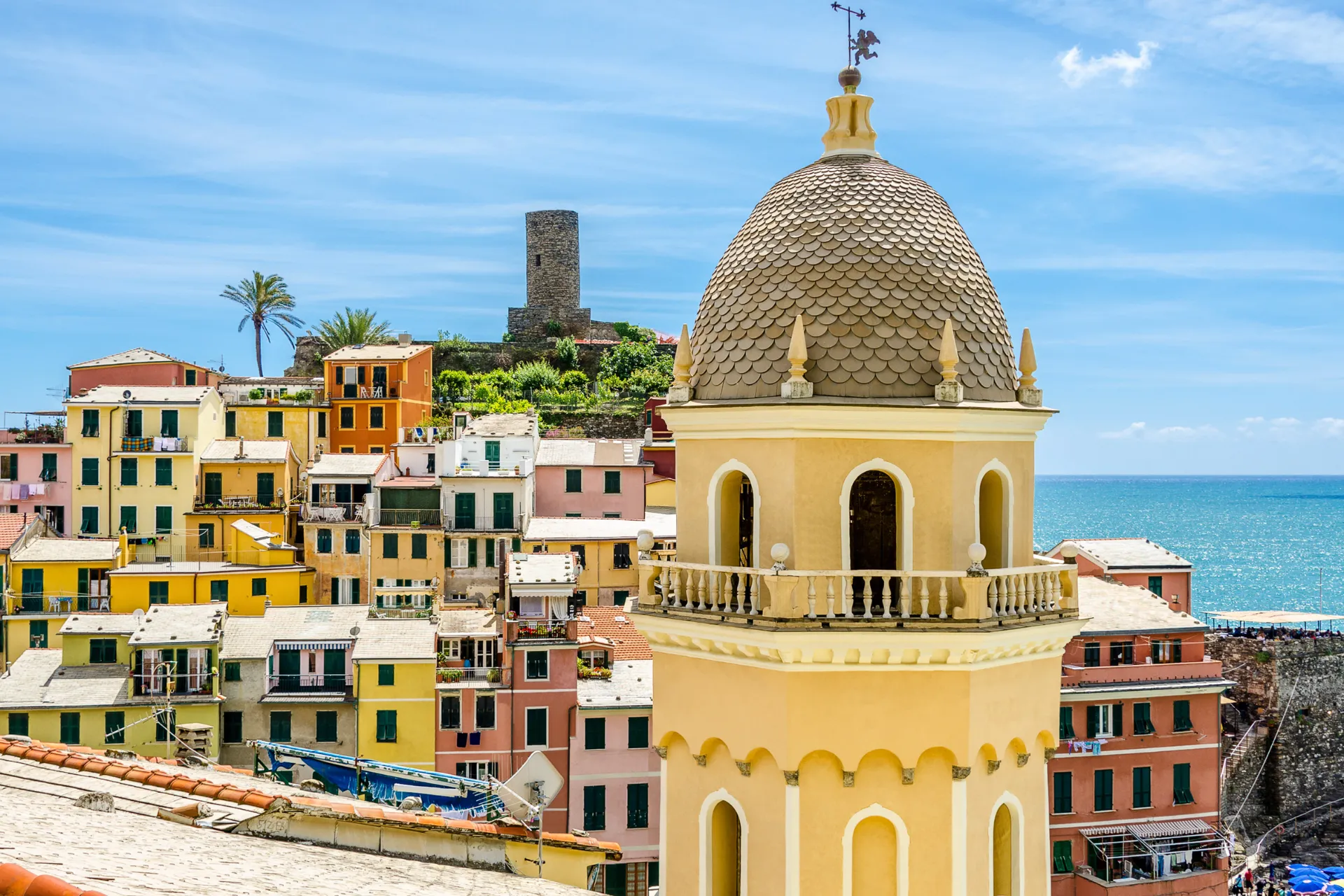 Kirketårn i Vernazza med farverige huse og havudsigt