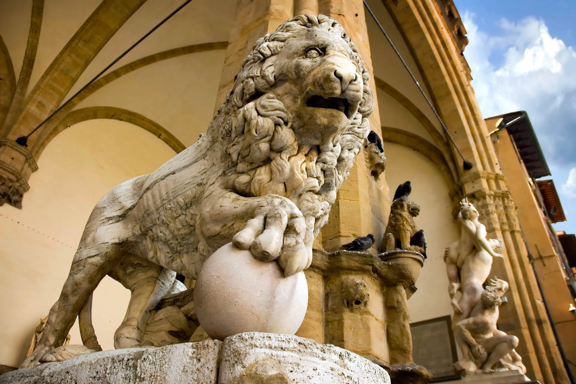 Løveskulptur i marmor omgivet af kunstneriske detaljer