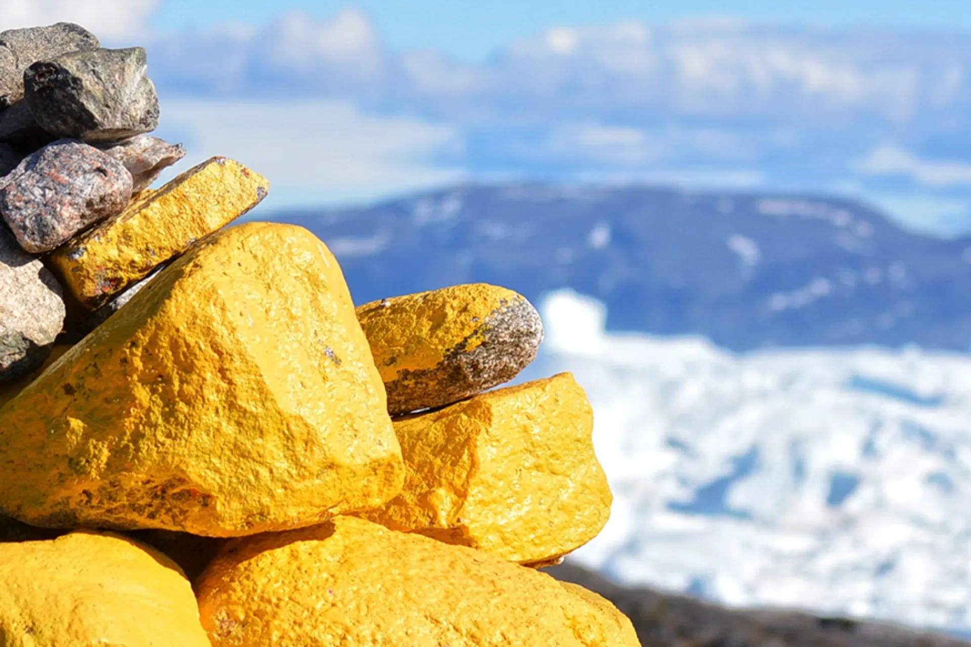 En vardestak med gule og grå sten med udsigt over isfjorden En vardestak med gule og grå sten med udsigt over isfjorden