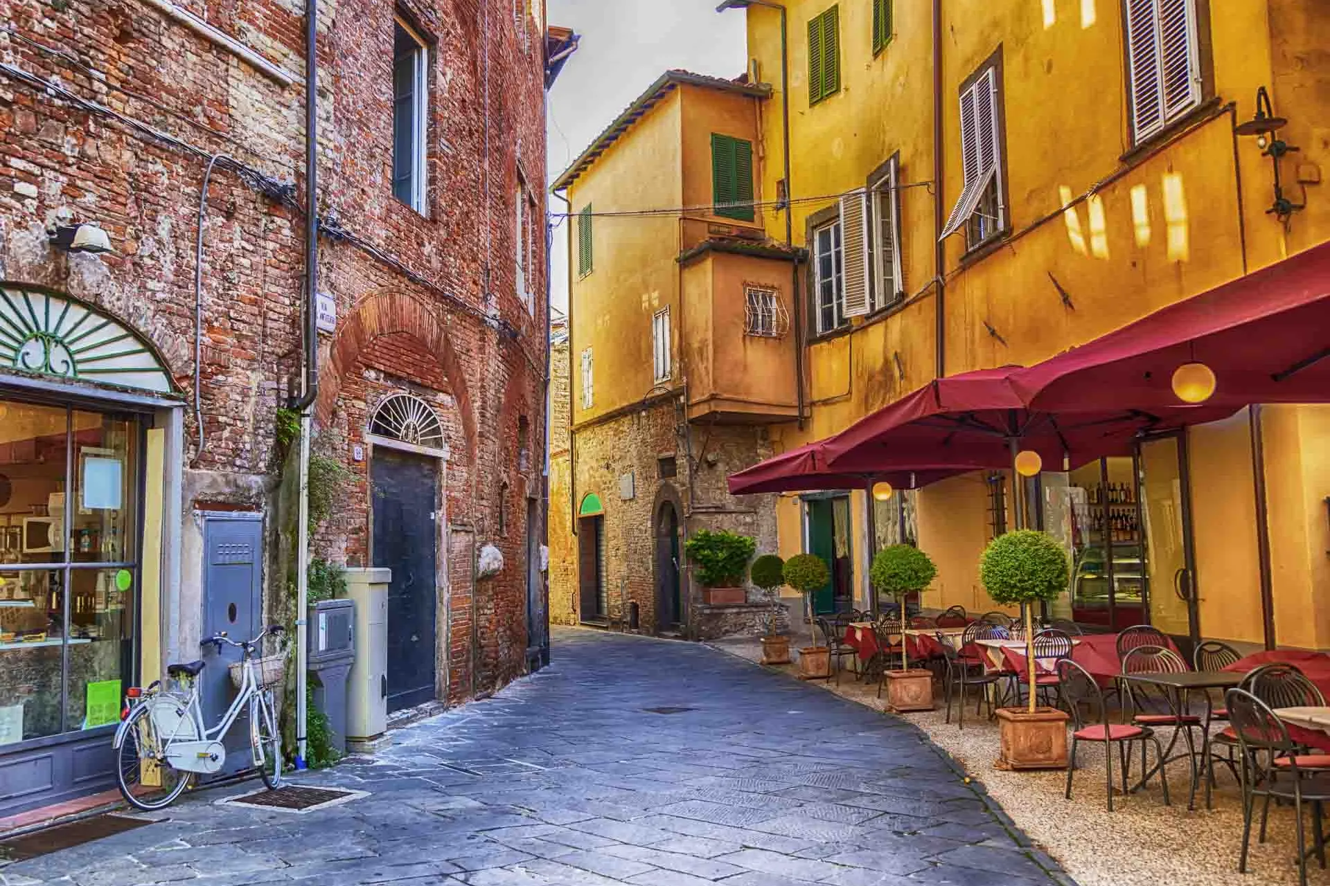 Hyggelig gade i Lucca med café og farverige huse