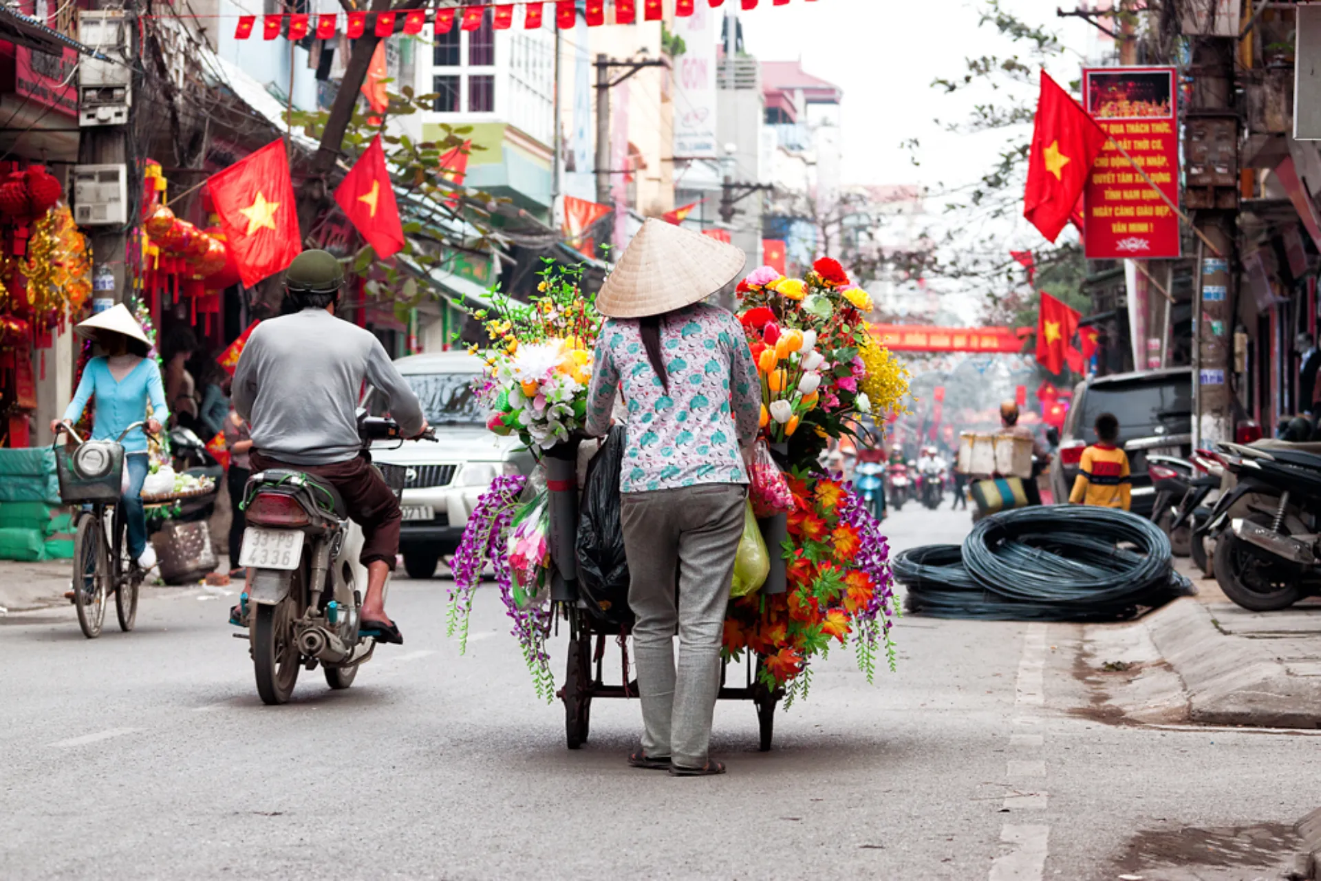 Blomstersælger på en travl gade i Hanoi Blomstersælger på en travl gade i Hanoi
