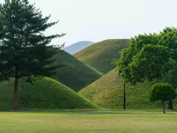 De imponerende græsklædte gravhøje i Daereungwon Gravkomplekset i Gyeongju De imponerende græsklædte gravhøje i Daereungwon Gravkomplekset i Gyeongju
