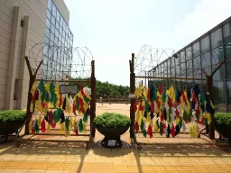 DMZ – farverige bånd hængt på hegnet symboliserer ønsker om fred og genforening mellem Nord- og Sydkorea DMZ – farverige bånd hængt på hegnet symboliserer ønsker om fred og genforening mellem Nord- og Sydkorea