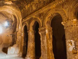 Indre af en gammel hulekirke i Kappadokien, med udskårne søjler, buer og rester af dekorationer i klippevæggene