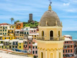 Kirketårn i Vernazza med farverige huse og havudsigt