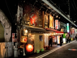 Stemningsfuld gade i Tokyo med autentiske, intime spisesteder under jernbanesporene