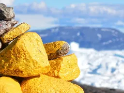 En vardestak med gule og grå sten med udsigt over isfjorden En vardestak med gule og grå sten med udsigt over isfjorden