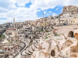 Uchisar-slottet i Kappadokien rejser sig over byen, omgivet af huse og huler hugget ind i de bløde klipper