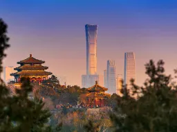 Solnedgang i Beijing med gammelt tempel og moderne skyskrabere