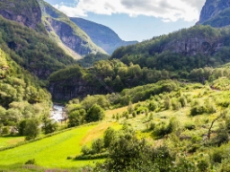 Toget kører langs brusende elve, fjelde og frodige dale