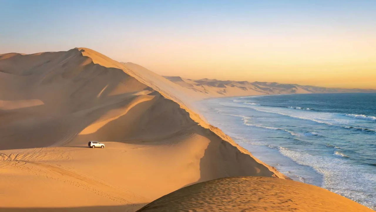 Sandwich Harbour i Namibia, hvor de høje klitter skråner direkte ned i havet Sandwich Harbour i Namibia, hvor de høje klitter skråner direkte ned i havet