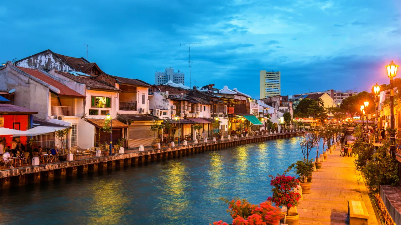 Aftenstemning langs Malacca-floden med historiske huse, caféer og oplyst promenade Aftenstemning langs Malacca-floden med historiske huse, caféer og oplyst promenade