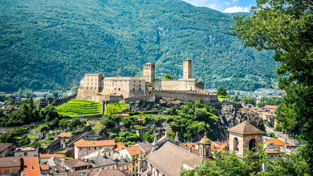 Castelgrande troner over Bellinzona med Alperne i baggrunden