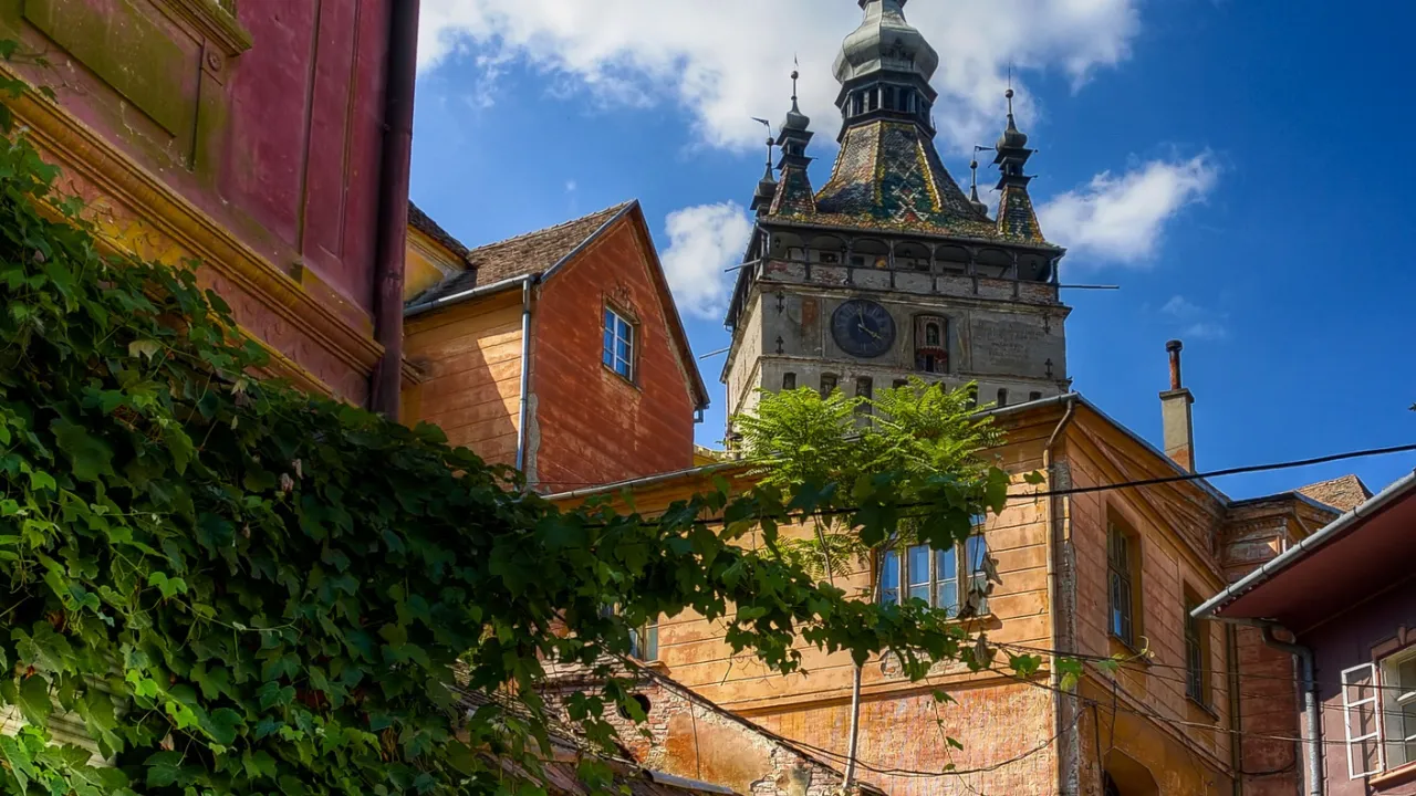 Brostensbelagt gade i Sighișoara med udsigt til det ikoniske klokketårn
