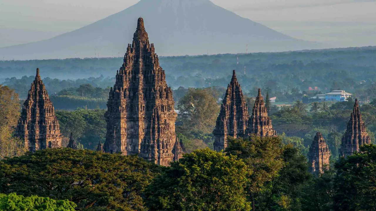 Prambanan-templet i Centraljava med vulkanen Merapi i baggrunden