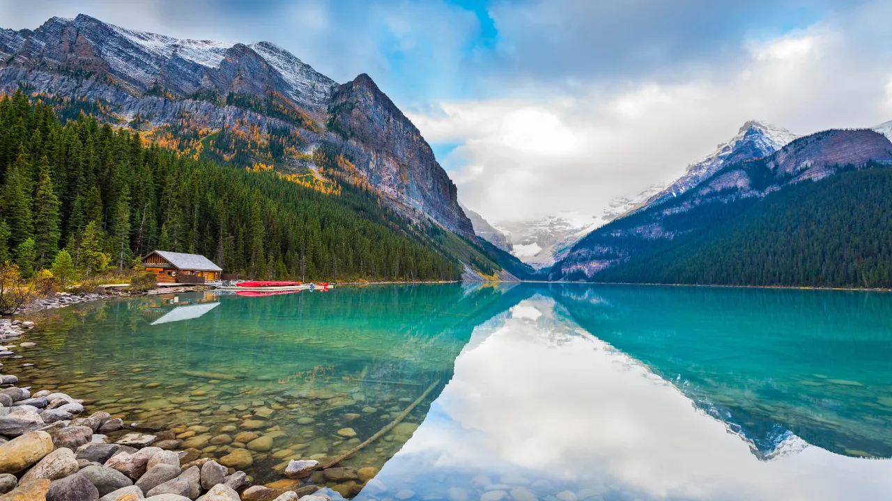 Betagende natur ved Lake Louise med skovklædte bjergskråninger i Banff National Park, Alberta