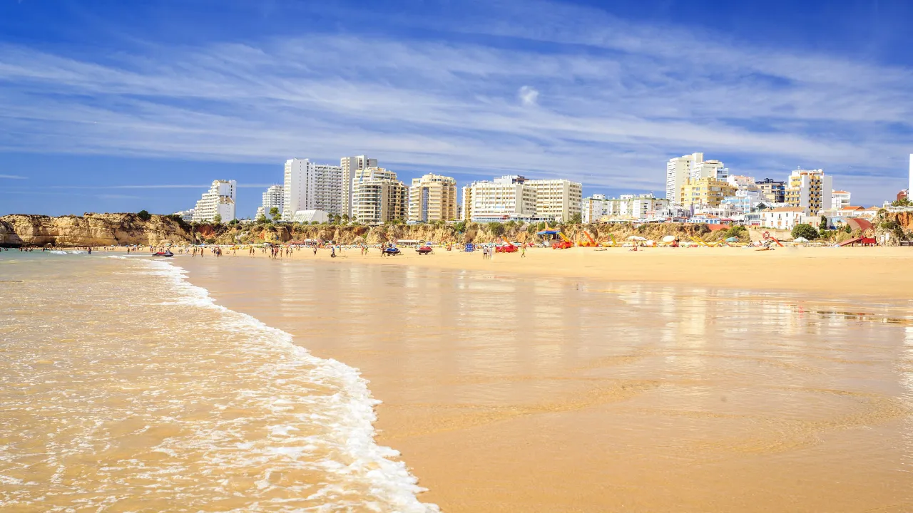 Portimão i baggrunden og den lokkende strand Praia da Rocha i forgrunden Portimão i baggrunden og den lokkende strand Praia da Rocha i forgrunden