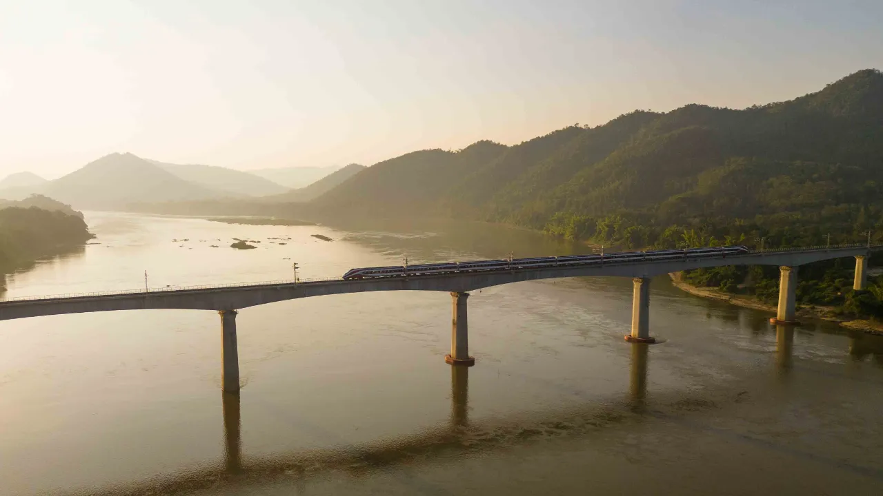 Tog på Laos-Kina-jernbanen gennem det bjergrige landskab i Laos Tog på Laos-Kina-jernbanen gennem det bjergrige landskab i Laos