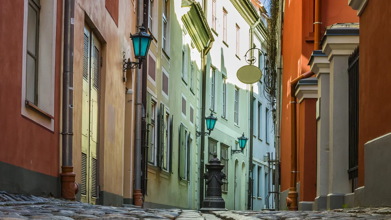 Smal, brostensbelagt gyde med farverige facader i den gamle bydel i Riga