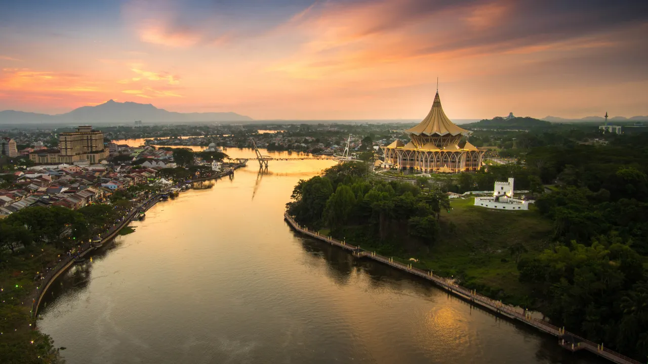 Solnedgang over Sarawak-floden i Kuching med byens vartegn Solnedgang over Sarawak-floden i Kuching med byens vartegn