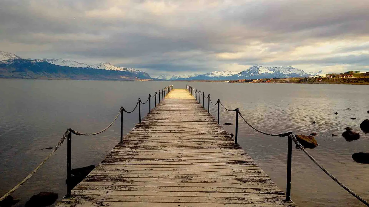 Fra træbro ved Puerto Natales har man udsigt over Última Esperanza-fjorden og de omkringliggende bjerge
