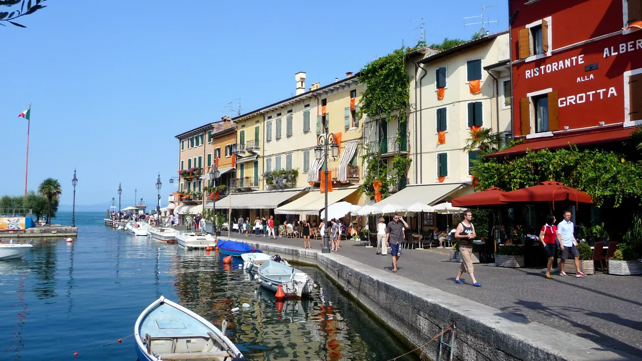 Havnen i Lazise ved Gardasøen med både, promenade og historiske bygninger langs vandet