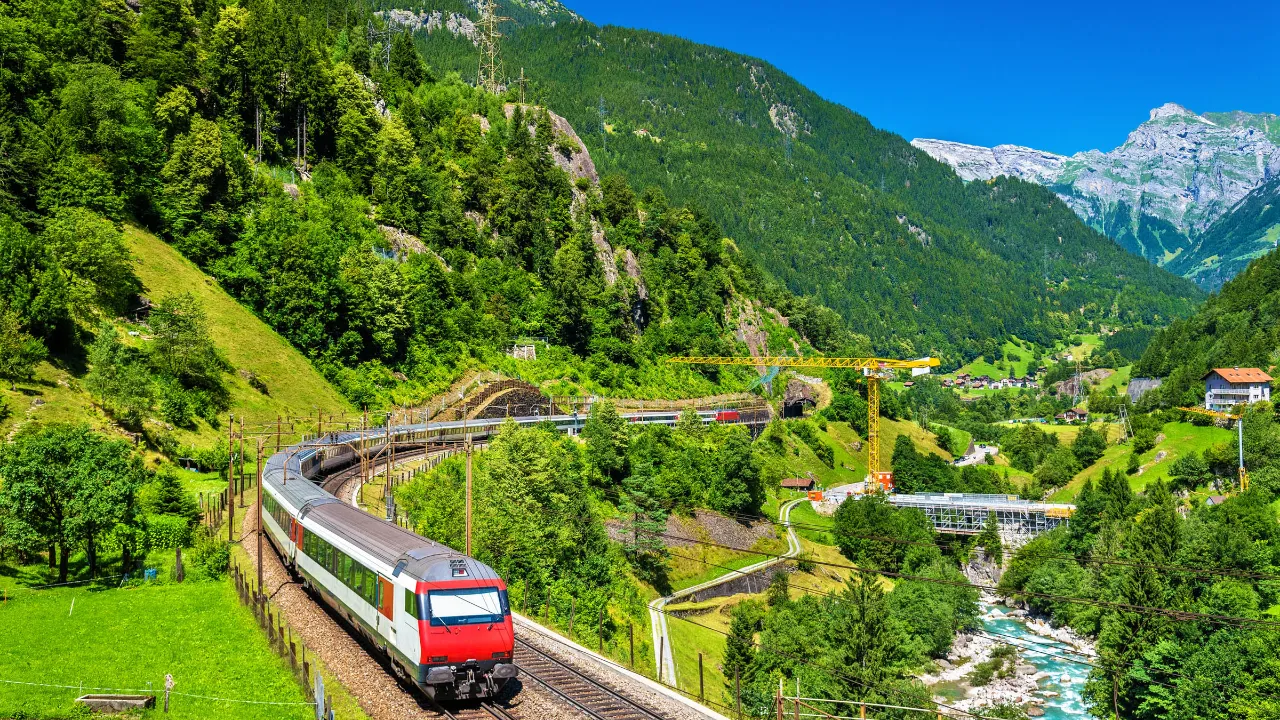 Tog på Gotthard-banen gennem den frodige alpedal