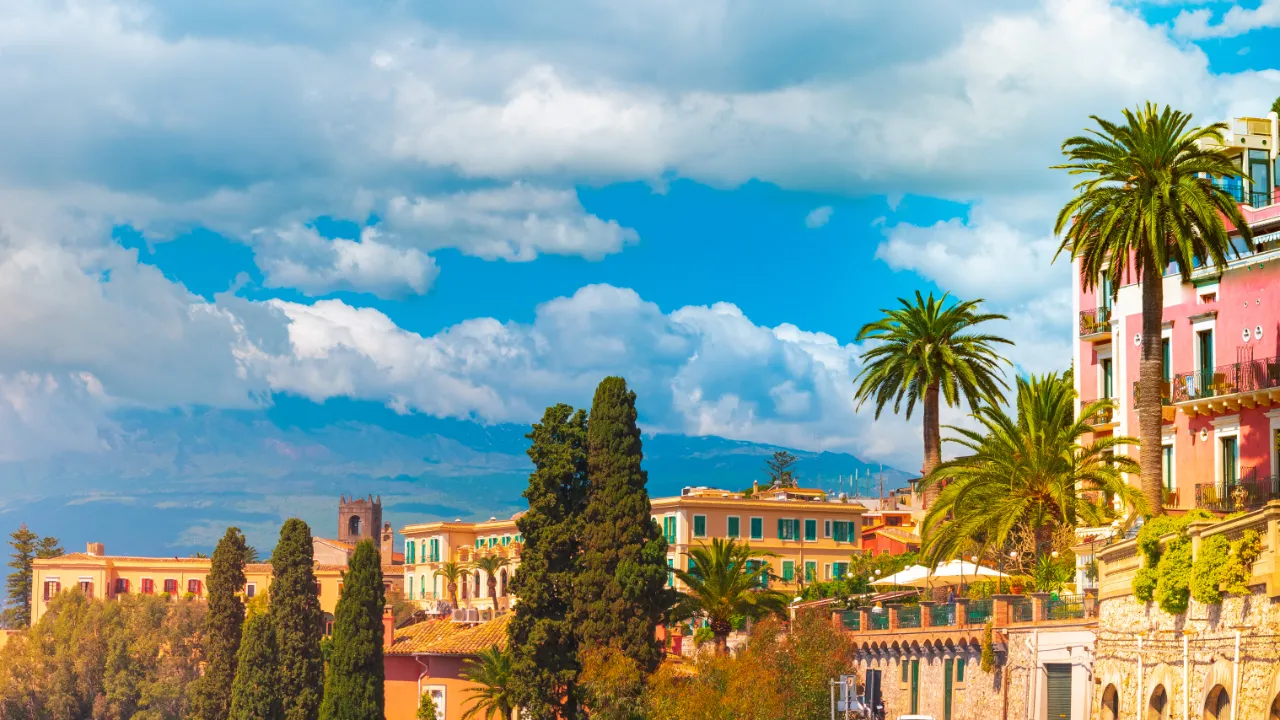 Taormina – med Etna-vulkanen i baggrunden delvist dækket af skyer. Taormina – med Etna-vulkanen i baggrunden delvist dækket af skyer.