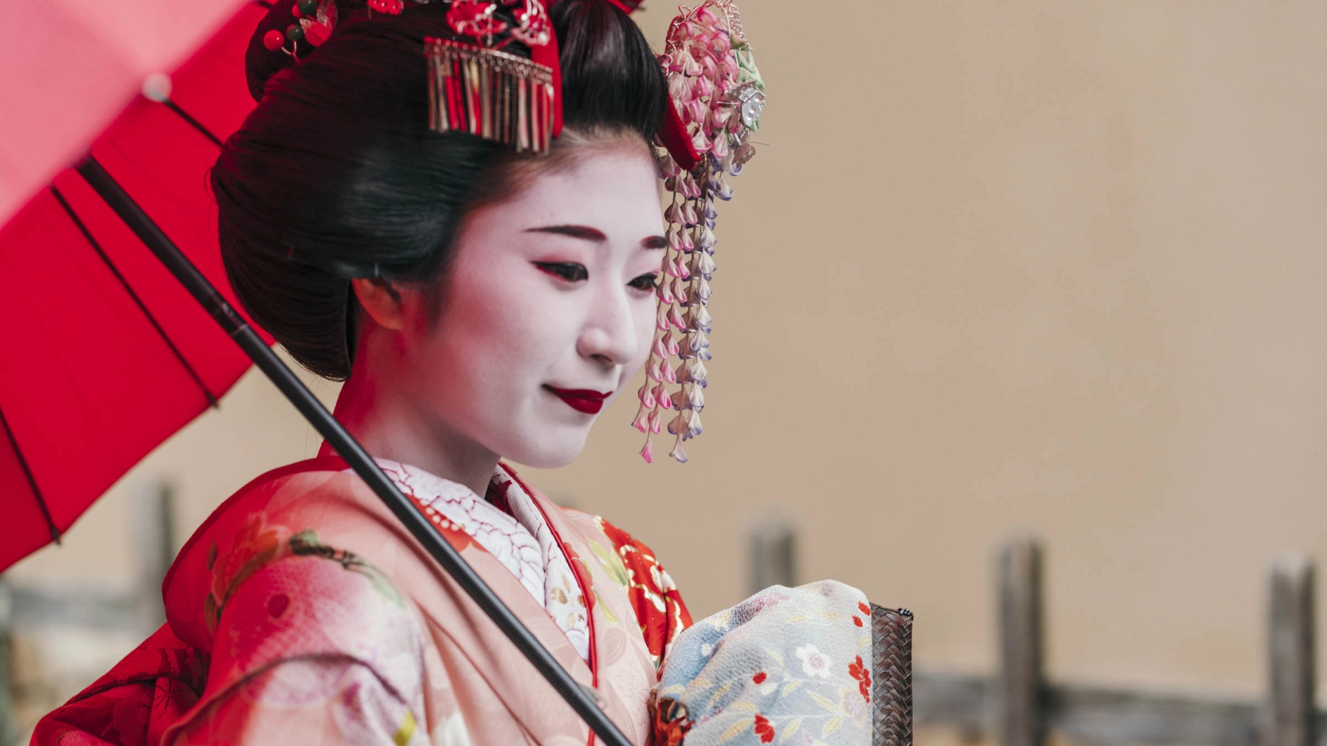 En smuk maiko (geisha-&quot;lærling&quot;) i traditionel kimono med paraply