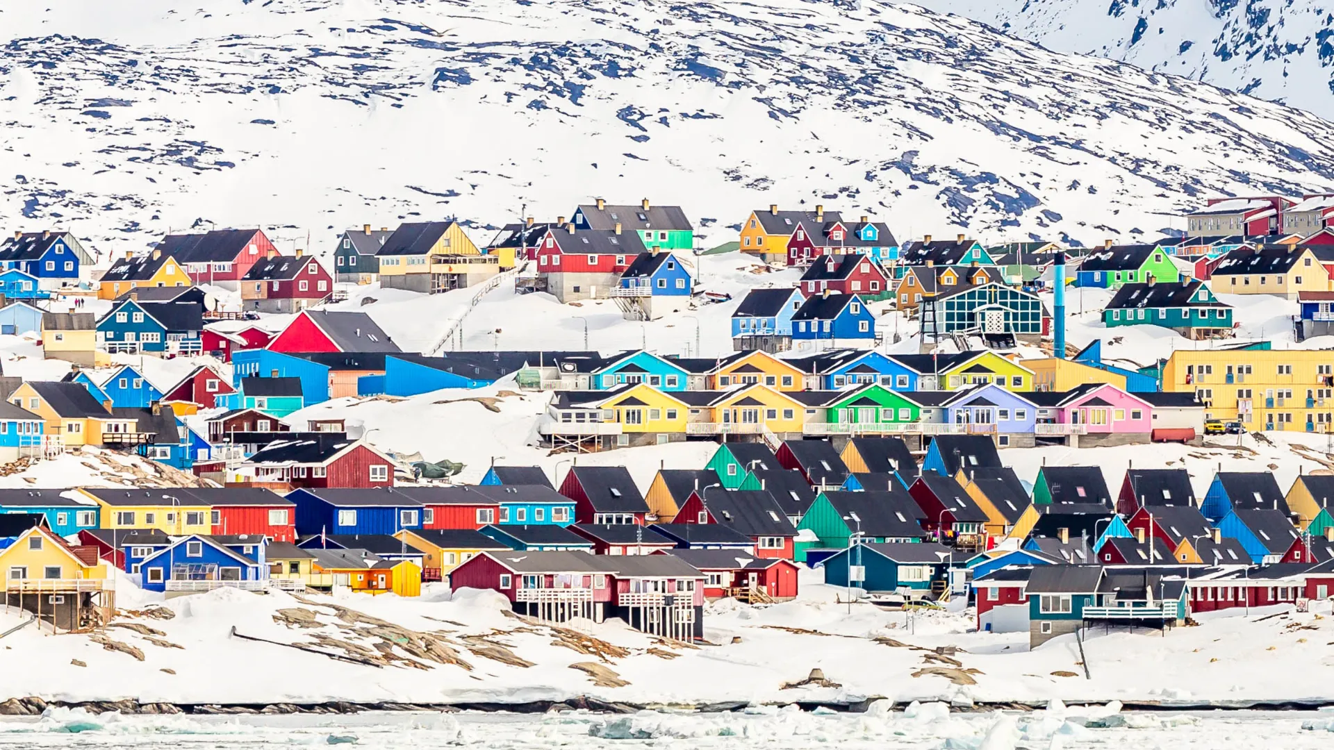 Farverige træhuse i Ilulissat – farven fortæller, hvem der bor i husene – eller rettere deres profession – de røde er f.eks. kirke, skole, handel Farverige træhuse i Ilulissat – farven fortæller, hvem der bor i husene – eller rettere deres profession – de røde er f.eks. kirke, skole, handel